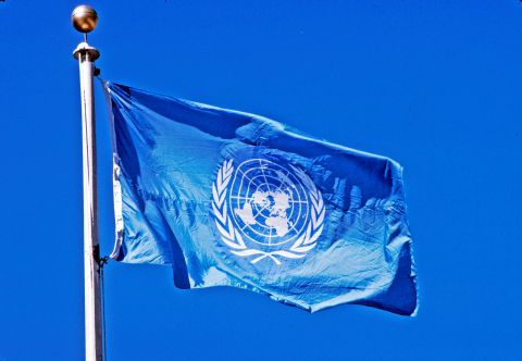 un-flag-flying-pole-blue-sky-behind-it