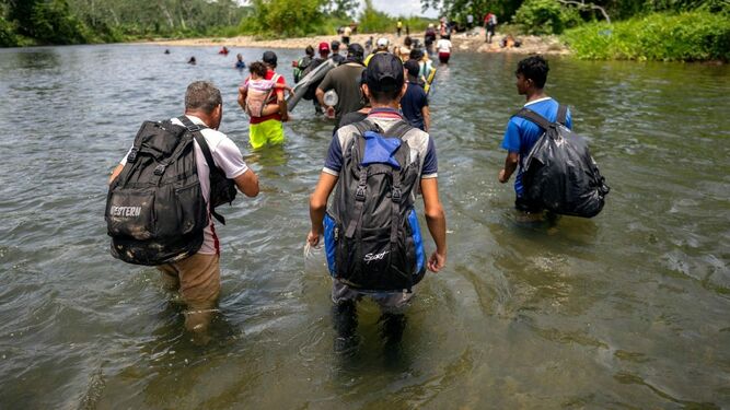 Migrantes atravesando el río Turquesa cerca del pueblo de Bajo Chiquito