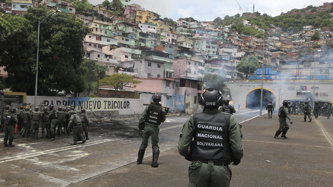 Miembros de la Guardia Nacional Bolivariana despejan una calle bloqueada en Caracas